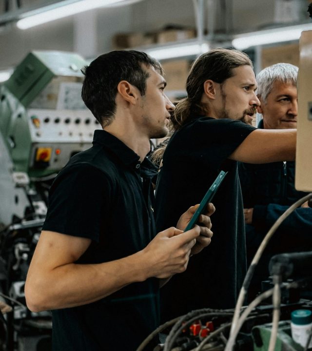 Engineers collaborating in an advanced manufacturing facility, focusing on machinery operations.